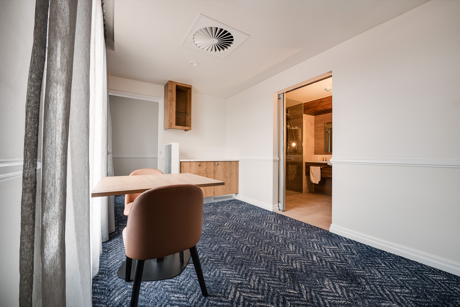 Suite entry with dining table and open bathroom doorway