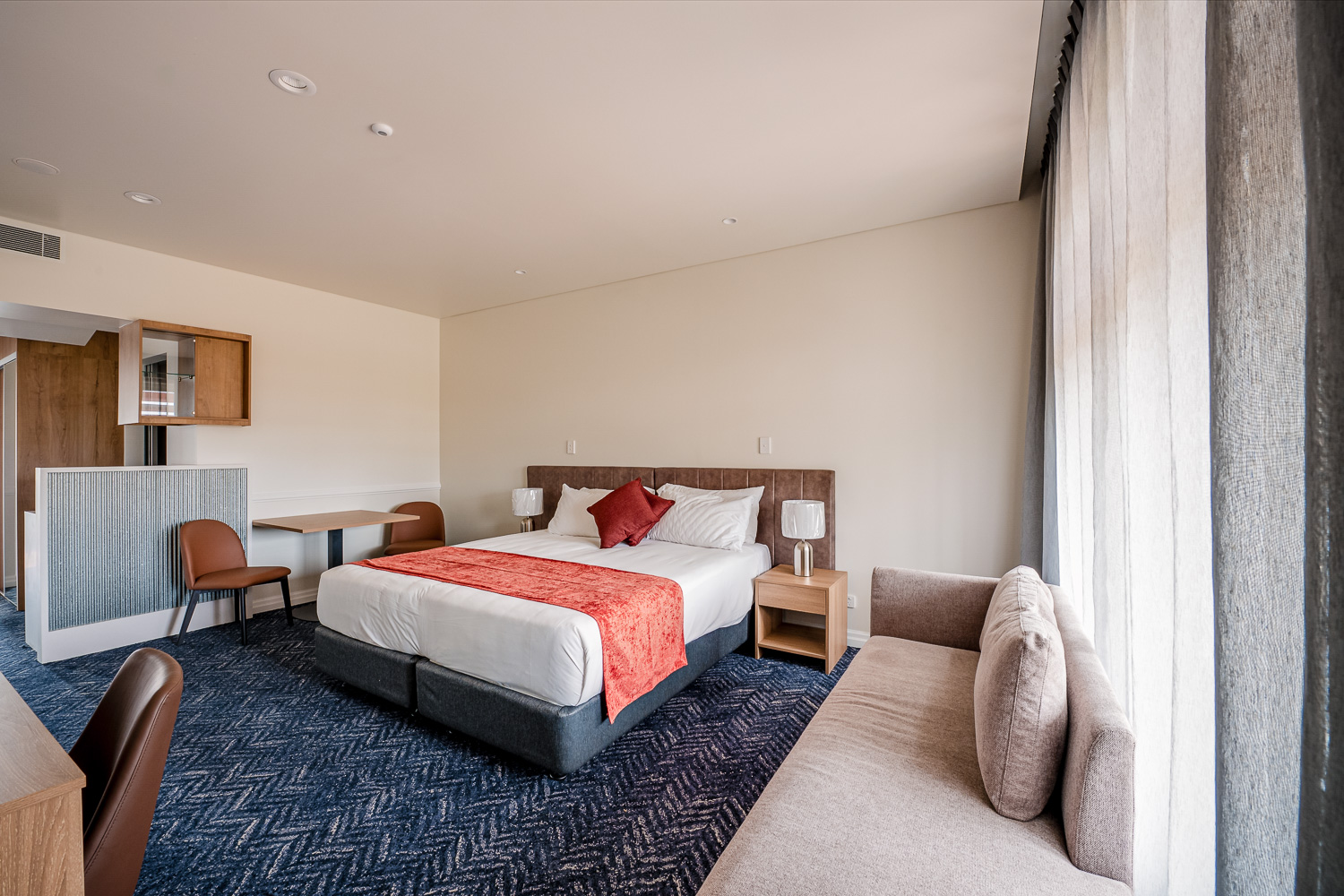 King suite with bed, dining table and lounge at Logan Village Hotel Suites