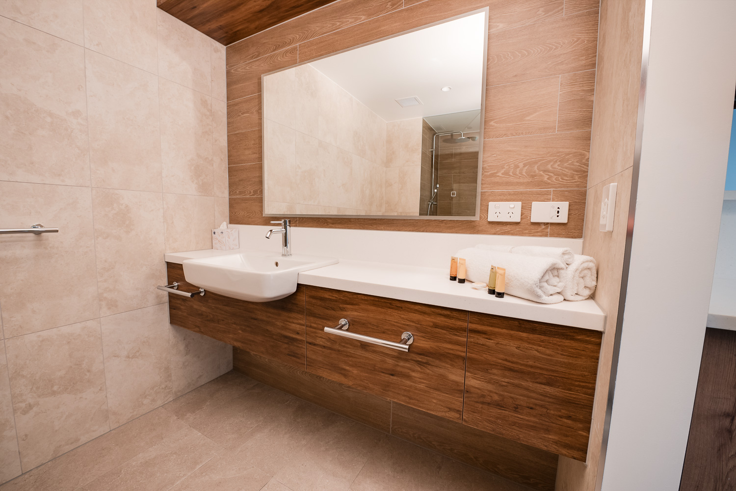 Accessible bathroom vanity with support rails and folded towels