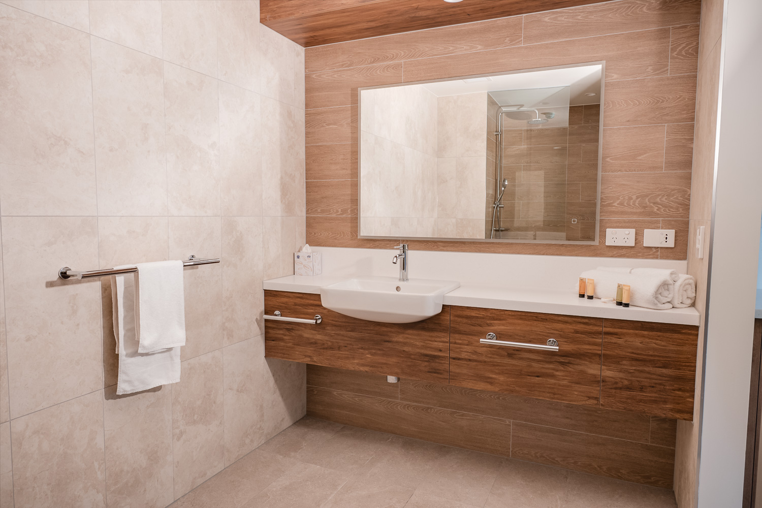 Bathroom vanity with mirror, towel rail and amenities