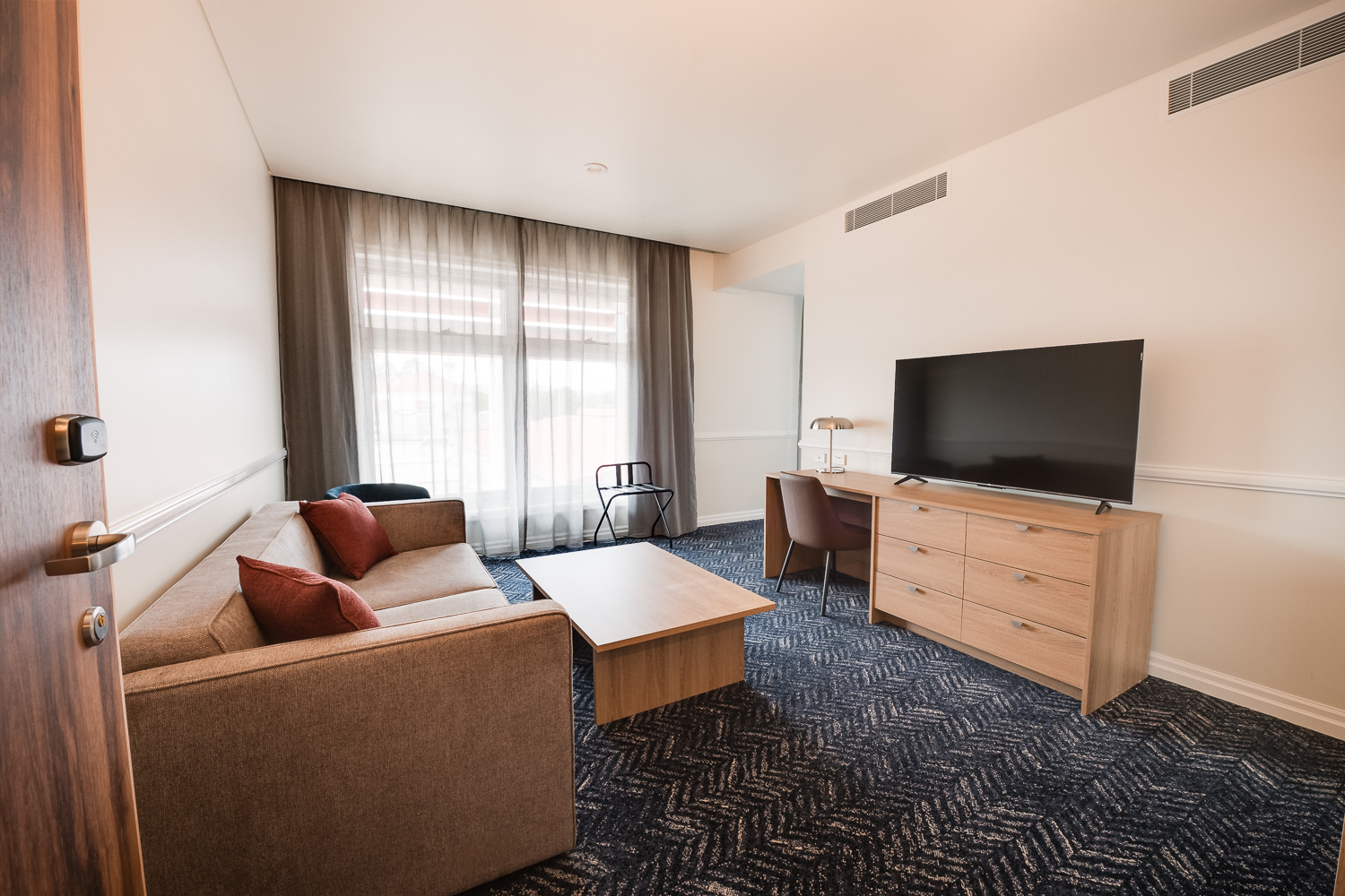 Suite living area with lounge, coffee table and flat-screen television